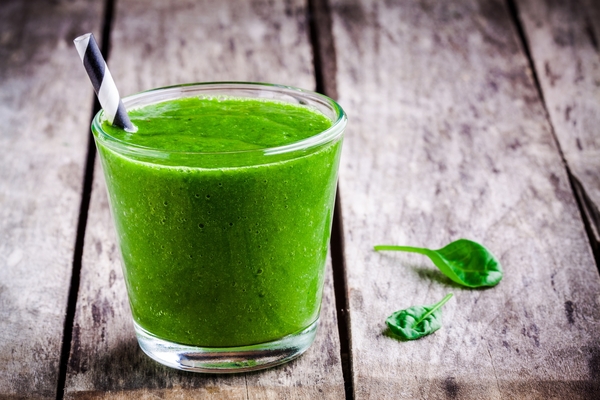 Batido verde en vaso con ingredientes frescos